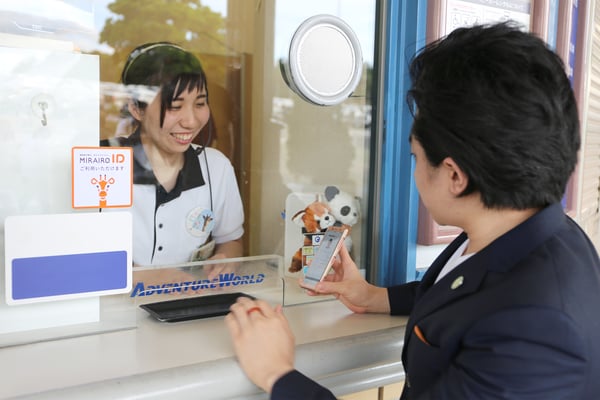【写真】車いすユーザーがスマホを窓口で掲示する様子