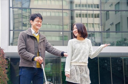 白杖をもつ人を手引きする様子