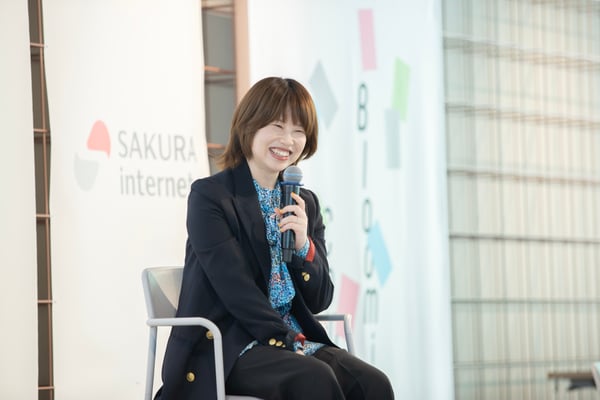 （写真）岸田奈美さんがマイクを持って笑顔でお話されている様子