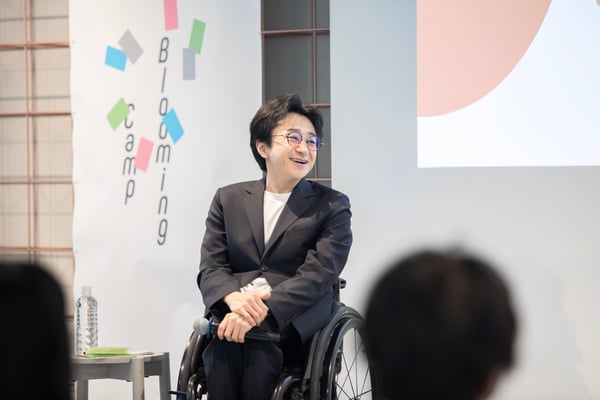 （写真）垣内が岸田奈美さんのお話を笑顔で聞いている様子