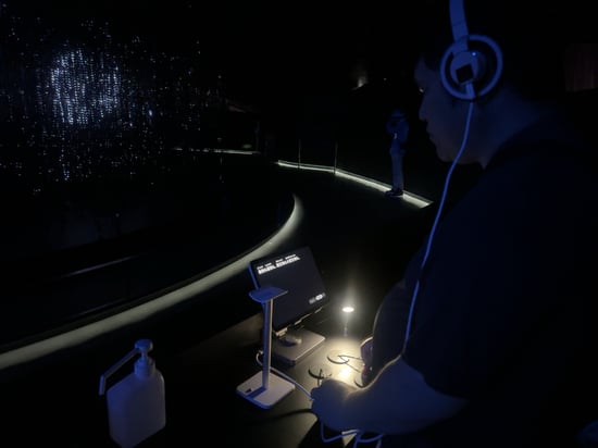 【写真】バビリオンで体験している様子。専用のヘッドフォンをつけている。