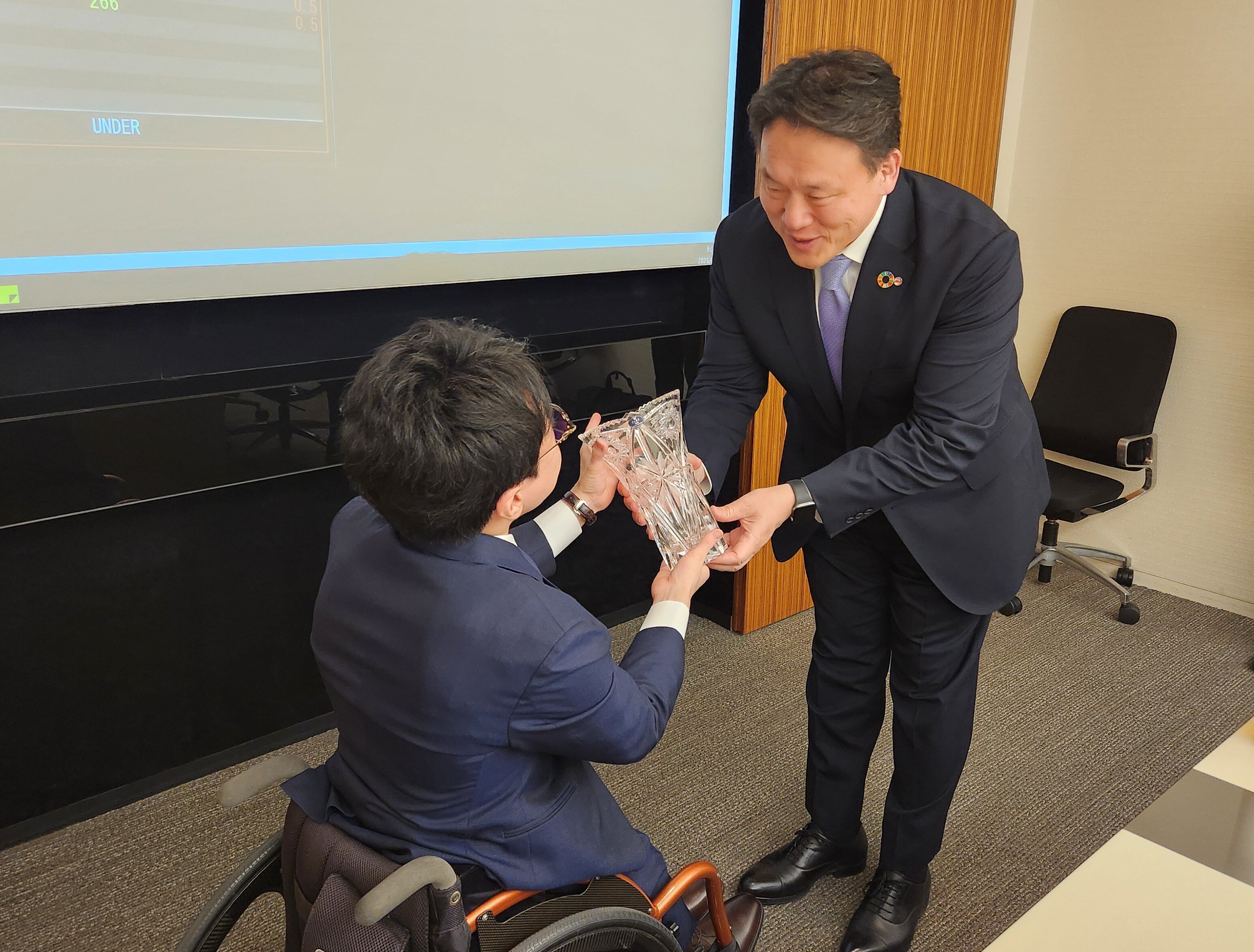 幹事証券会社の方より贈呈品を受領している垣内の写真