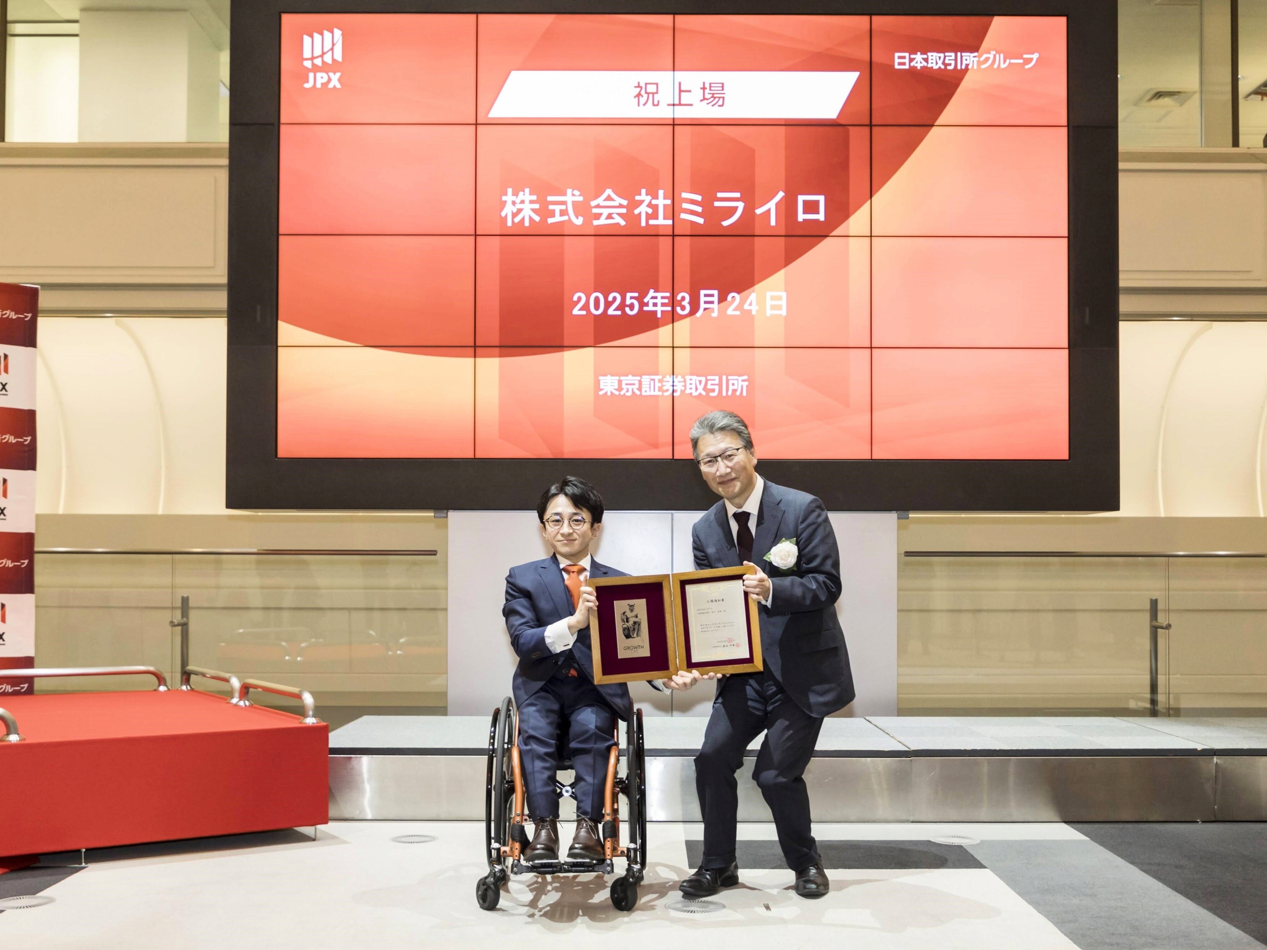 東京証券取引所の方より贈呈品を受領したあとのツーショット写真