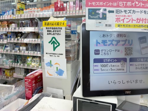 （写真）店舗のカウンターに設定されている筆談対応可能ステッカー