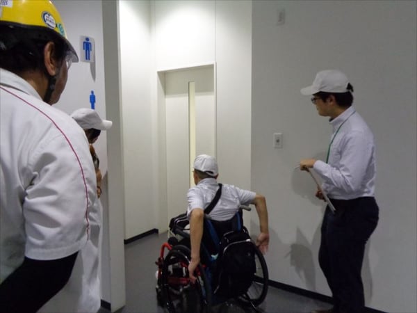 画像　車いすに乗ってバリアをチェックする様子
