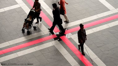 写真　暗い色の地面に赤色のマットを敷いている様子