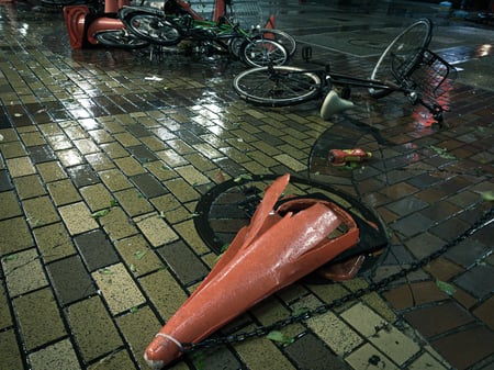 写真　台風のあと、カラーコーンや自転車が道に倒れて邪魔になっている