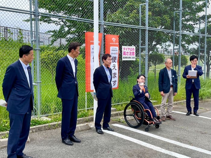駐車場での記者会見の様子の写真
