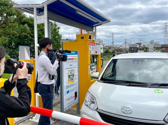 駐車場の精算機でQRコードをかざして減免を受ける様子の写真