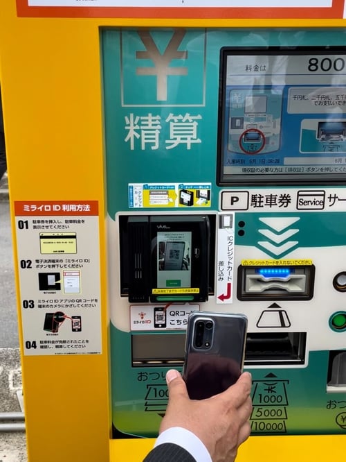 精算機にスマホのQRコードをかざす様子の写真
