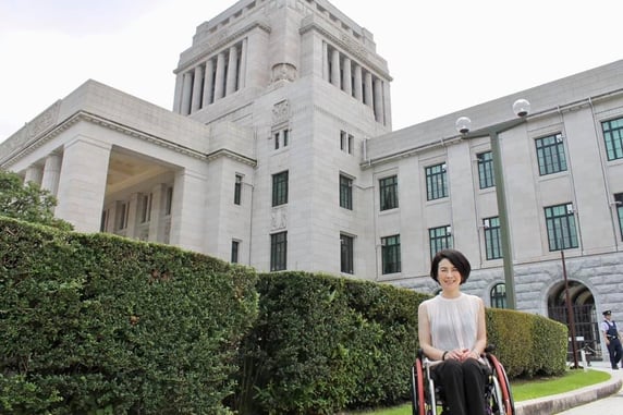 写真　国会議事堂と車いすユーザーの岸田