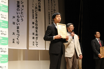 写真　委嘱状を手にしている田崎氏