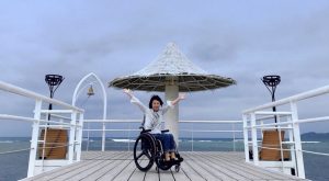 写真　車いすに乗って万歳する岸田
