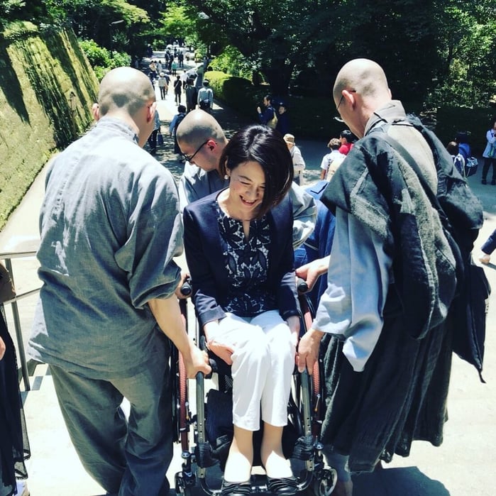 写真　和尚さんたちに階段を下ろしてもらう岸田
