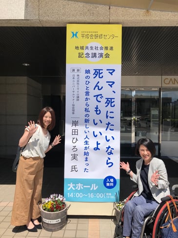 写真　岸田ひろ実が会場入口でポーズをとっている様子